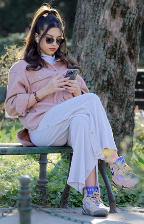 椅子上看手机的戴墨镜美女图片